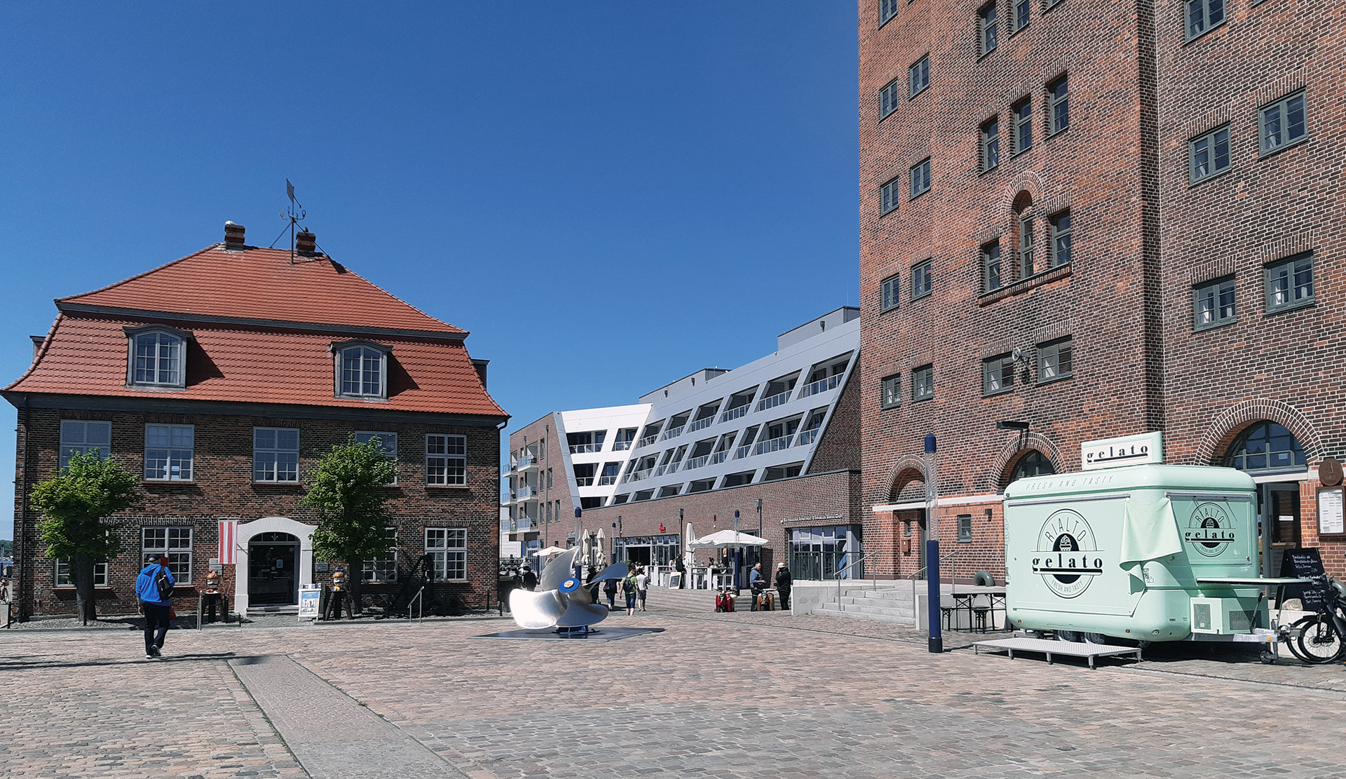 Ansicht des Gebäudes Hafenspitze Wismar am Alten Hafen zwischen historischem Baumhaus und altem Getreidespeicher . Neubau Wohn- und Geschäftshaus Hafenspitze, Wismar